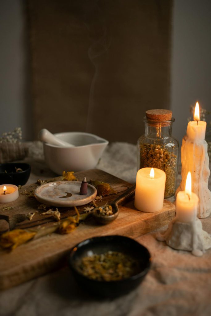 Spiritual Consultant UK - Trusted Traditional Healing Services - Herbs on wooden board next to burning candles