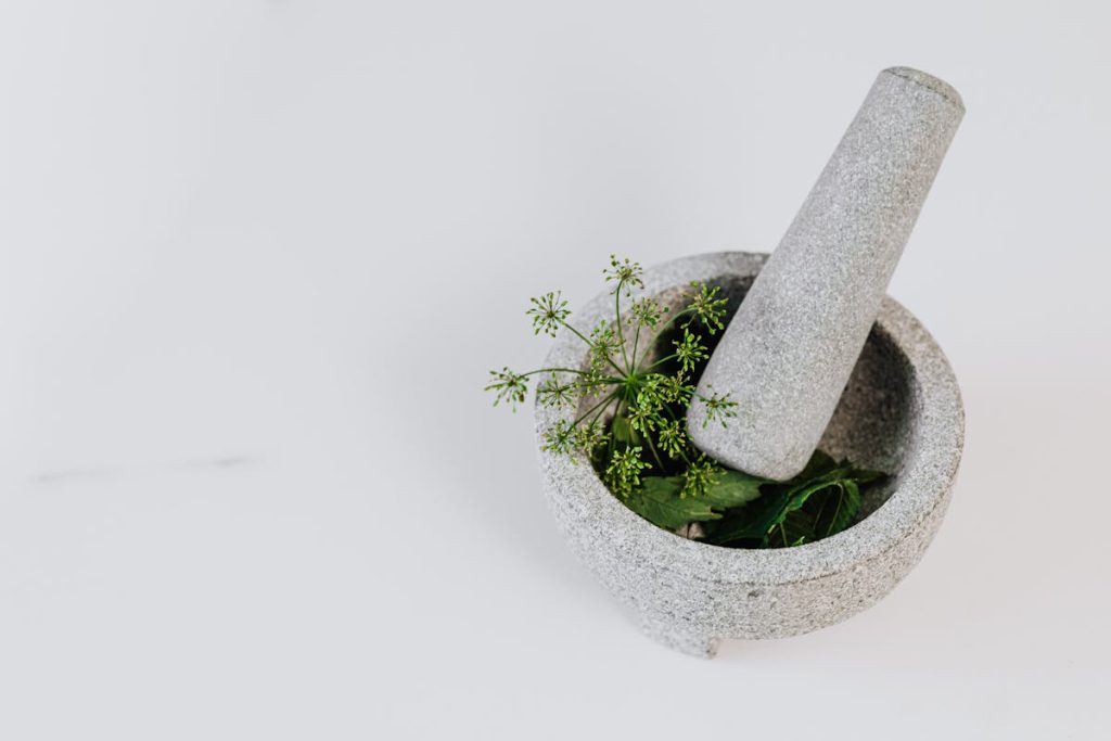 African Spiritual Healer UK - Cleansing, Protection, and Relationship Clarity - Mortar and pestle with green leaves and edible flowers