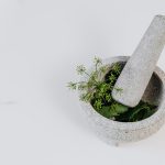 African Spiritual Healer UK - Cleansing, Protection, and Relationship Clarity - Mortar and pestle with green leaves and edible flowers